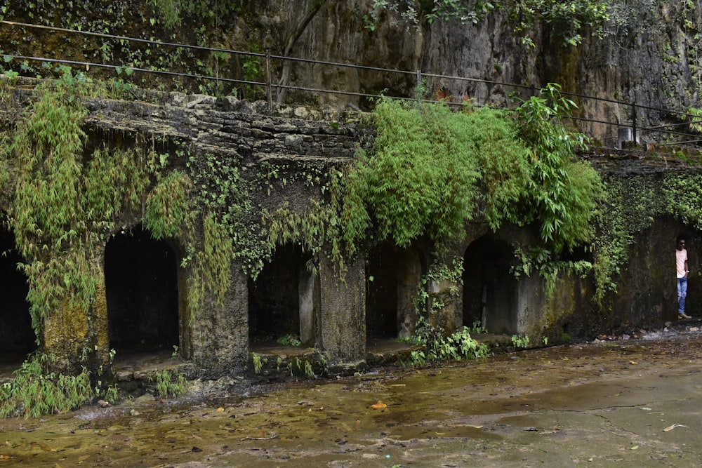 a man standing in a tunnel next to a river