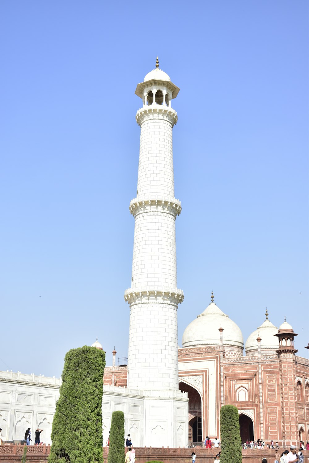 a tall white tower sitting next to a lush green park