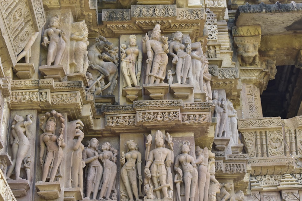 a close up of many statues on a building