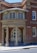 An entrance to a brick building with a rounded portico labeled 'Children's Court'. The structure features tall columns and an arched doorway with glass panes. A sign reading 'Albion St' is visible, along with a wheelchair accessibility symbol.