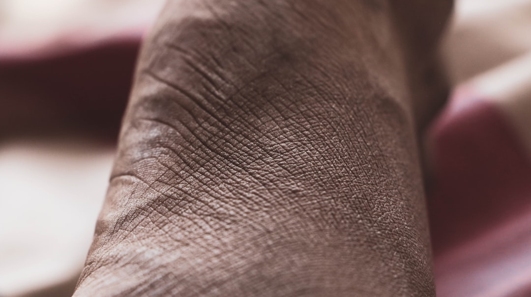 a close up of a person's foot with a pink blanket