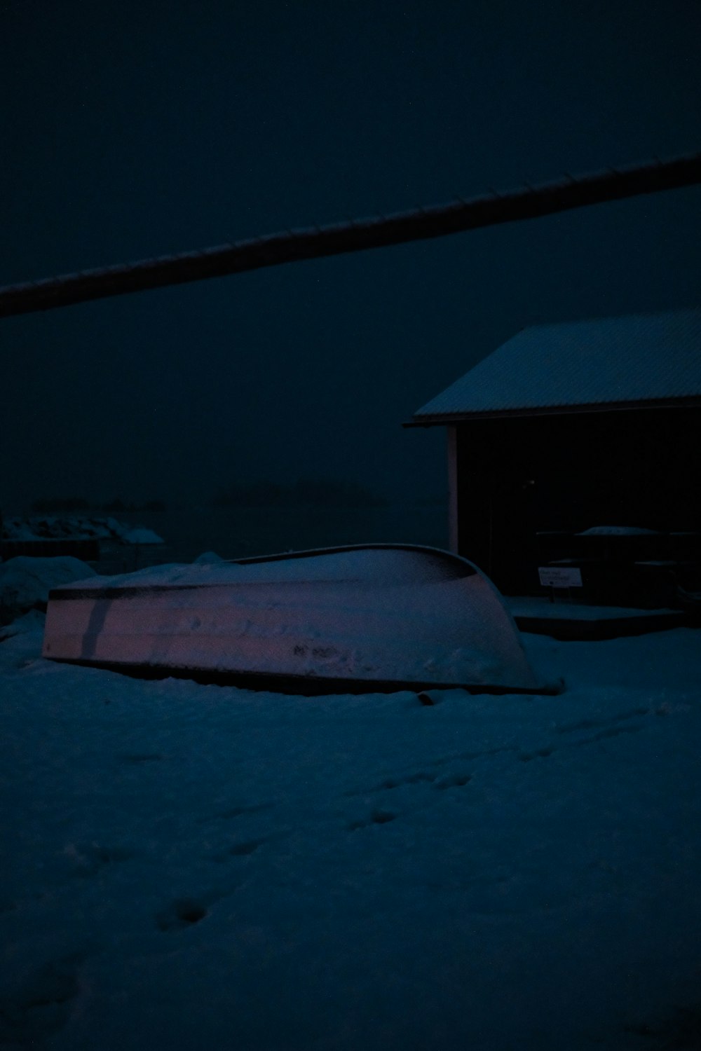 a snowboard laying in the snow at night