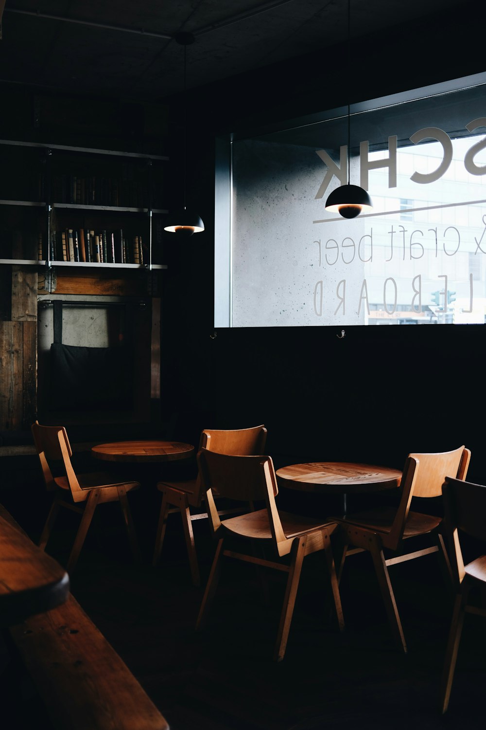 a dimly lit room with wooden chairs and tables