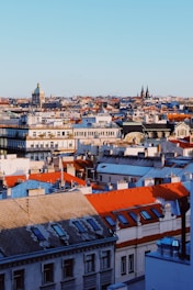 A vibrant collage of famous city landmarks from Europe, Asia, and the Middle East under a clear blue sky.