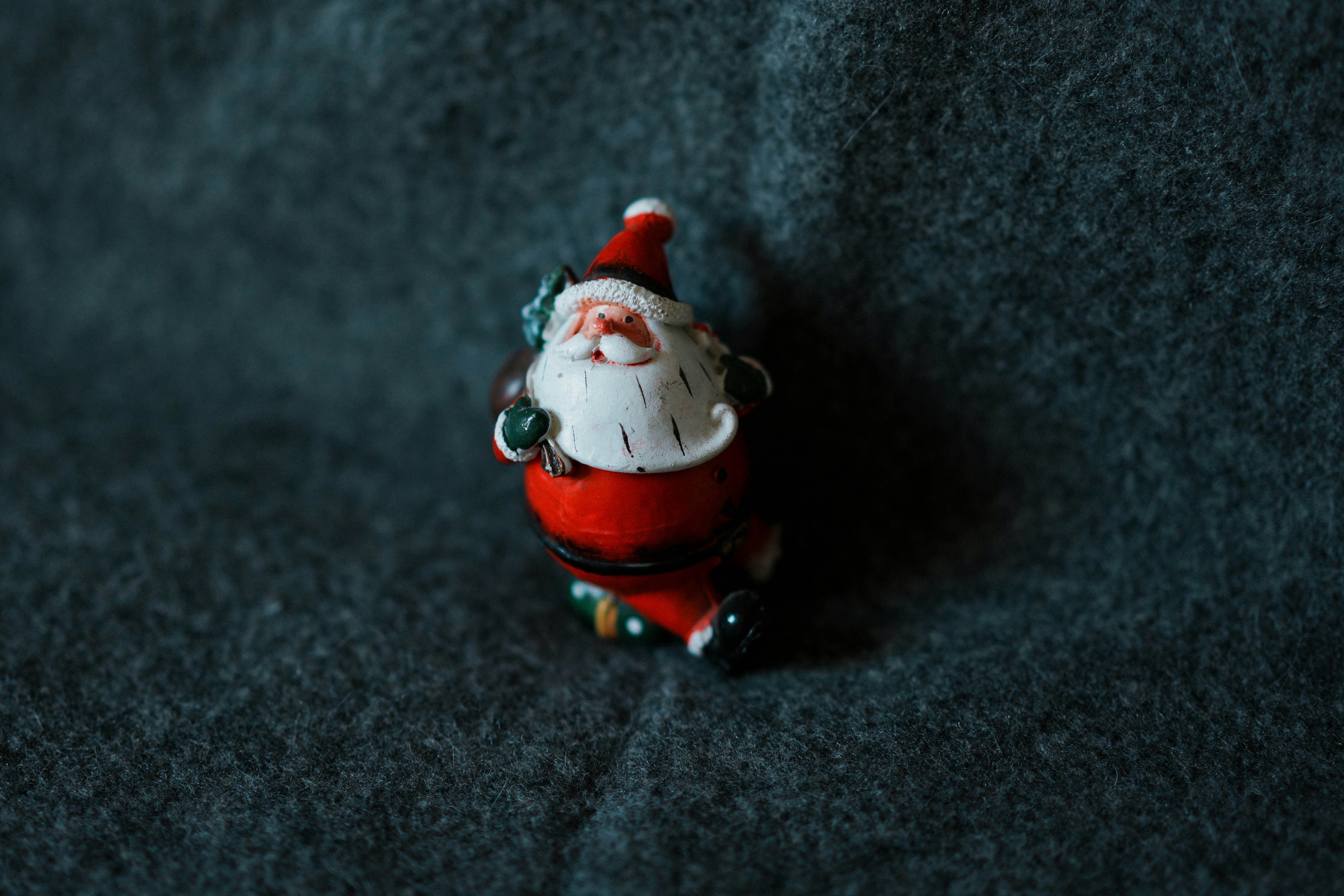 a santa clause figurine sitting on top of a blue blanket