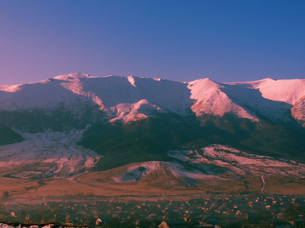 a snow covered mountain range with a town below