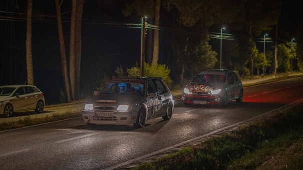 Close-up of the driver and co-driver focused inside the cockpit, instruments glowing under night rally conditions