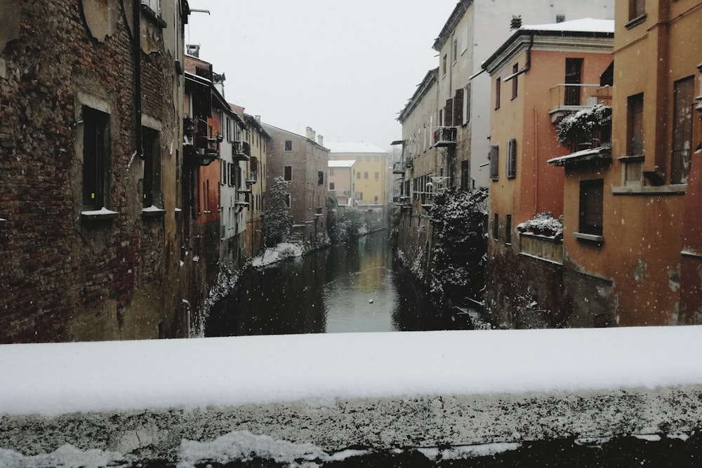 a narrow canal running between two buildings in the snow