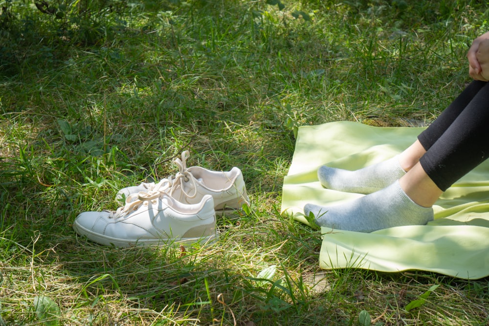 a person sitting on top of a blanket next to a pair of shoes