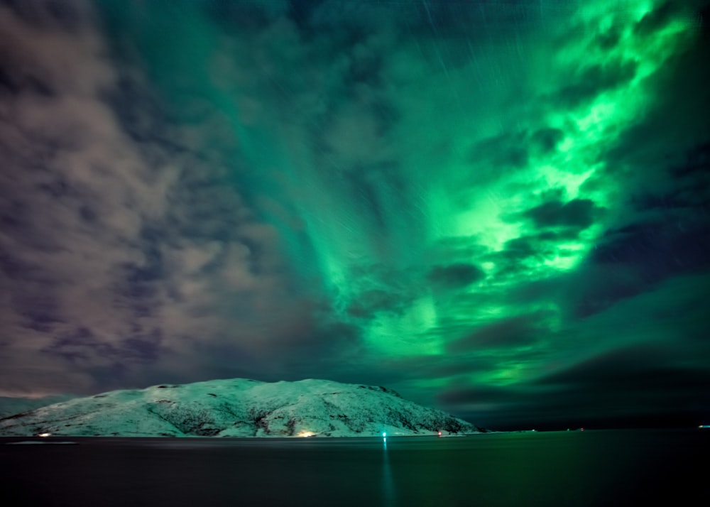 a green and blue aurora bore over a mountain