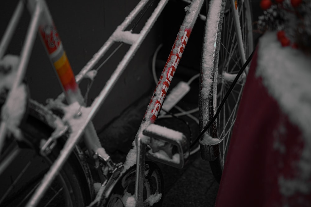 a bicycle is covered in snow with a red pole