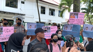 A group of people holding protest signs outside a government building.