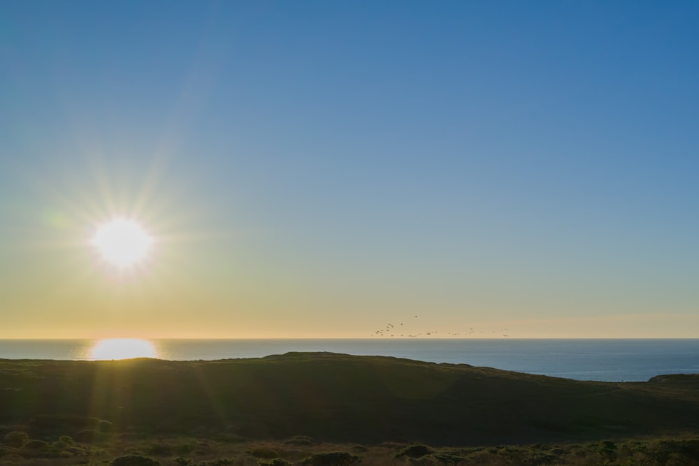 the sun is setting over the ocean on a clear day