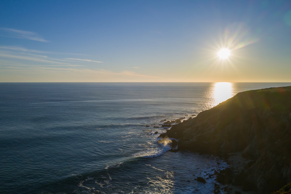 the sun is setting over the ocean on a clear day