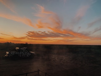 Sunset view over Mount Papandayan with a jeep parked on a rocky path.