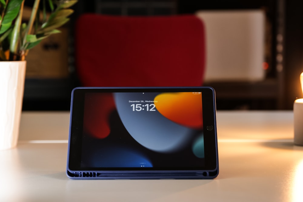 a tablet sitting on a table next to a candle