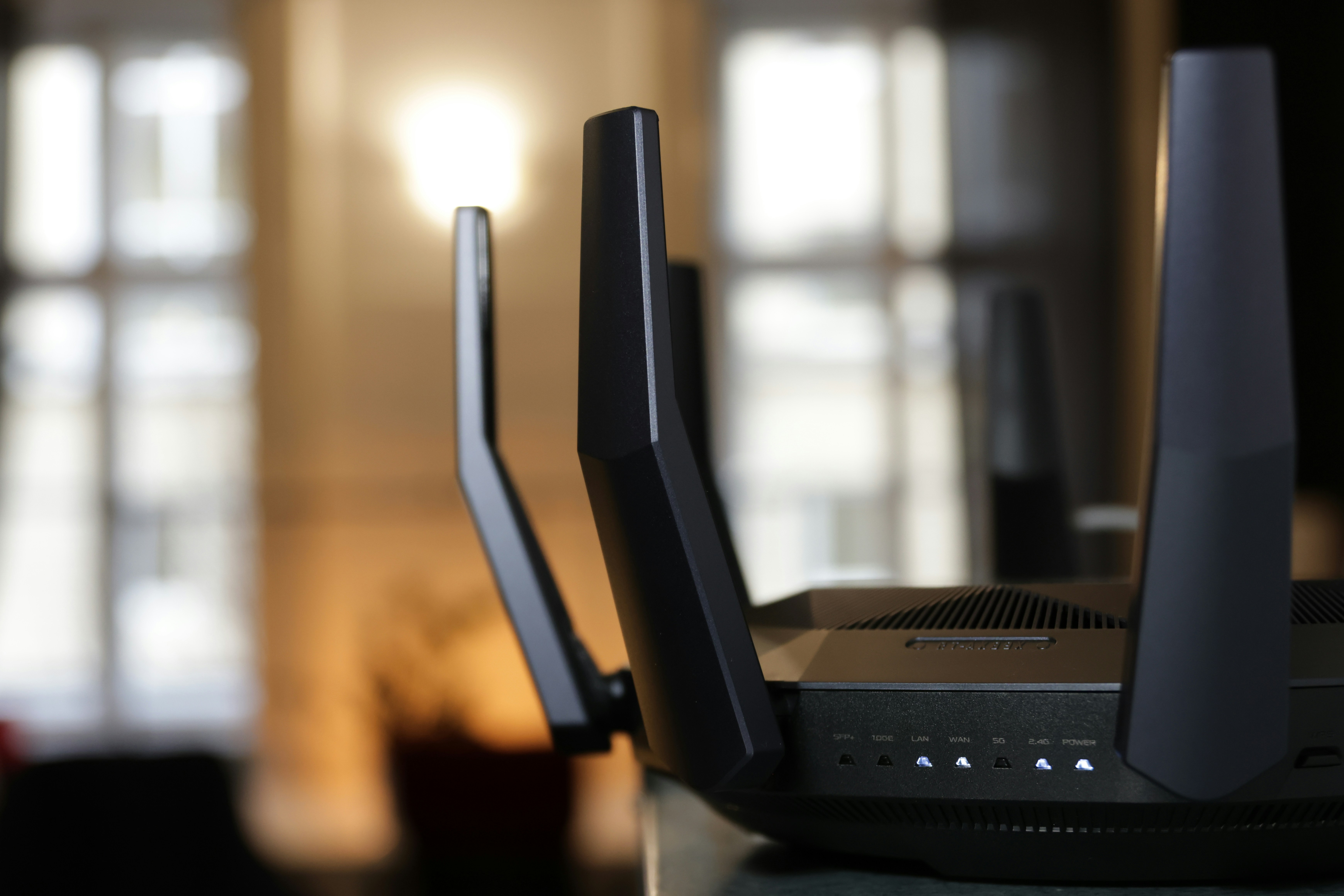 Black network router device with antennas on dark background