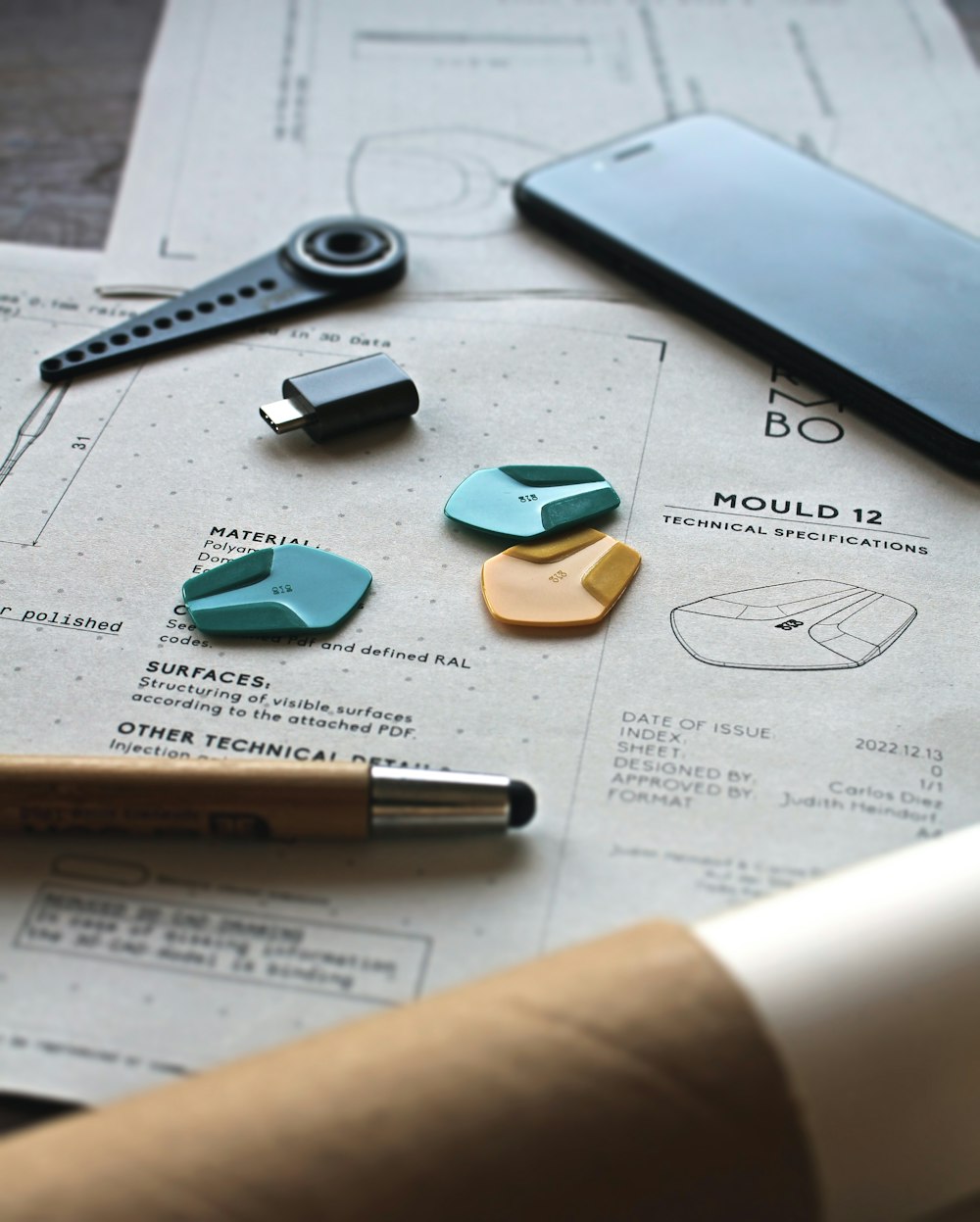 a table with a cell phone, pen, paper clip and other items on it