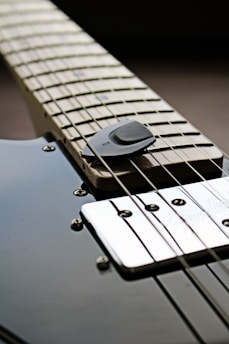 Close-up of a sleek steel guitar part with brushed metal finish reflecting city lights.