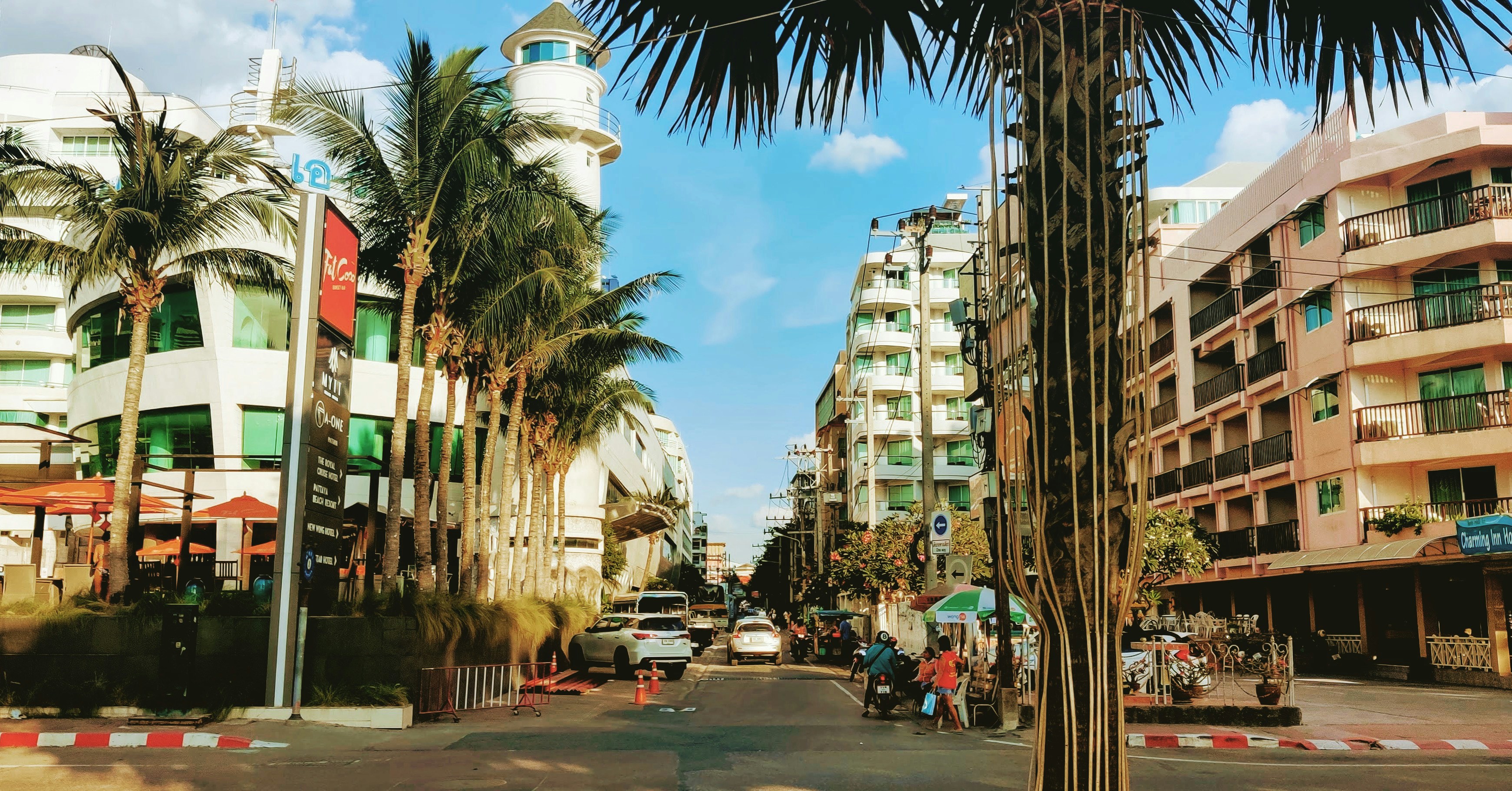 a city street with tall buildings and palm trees