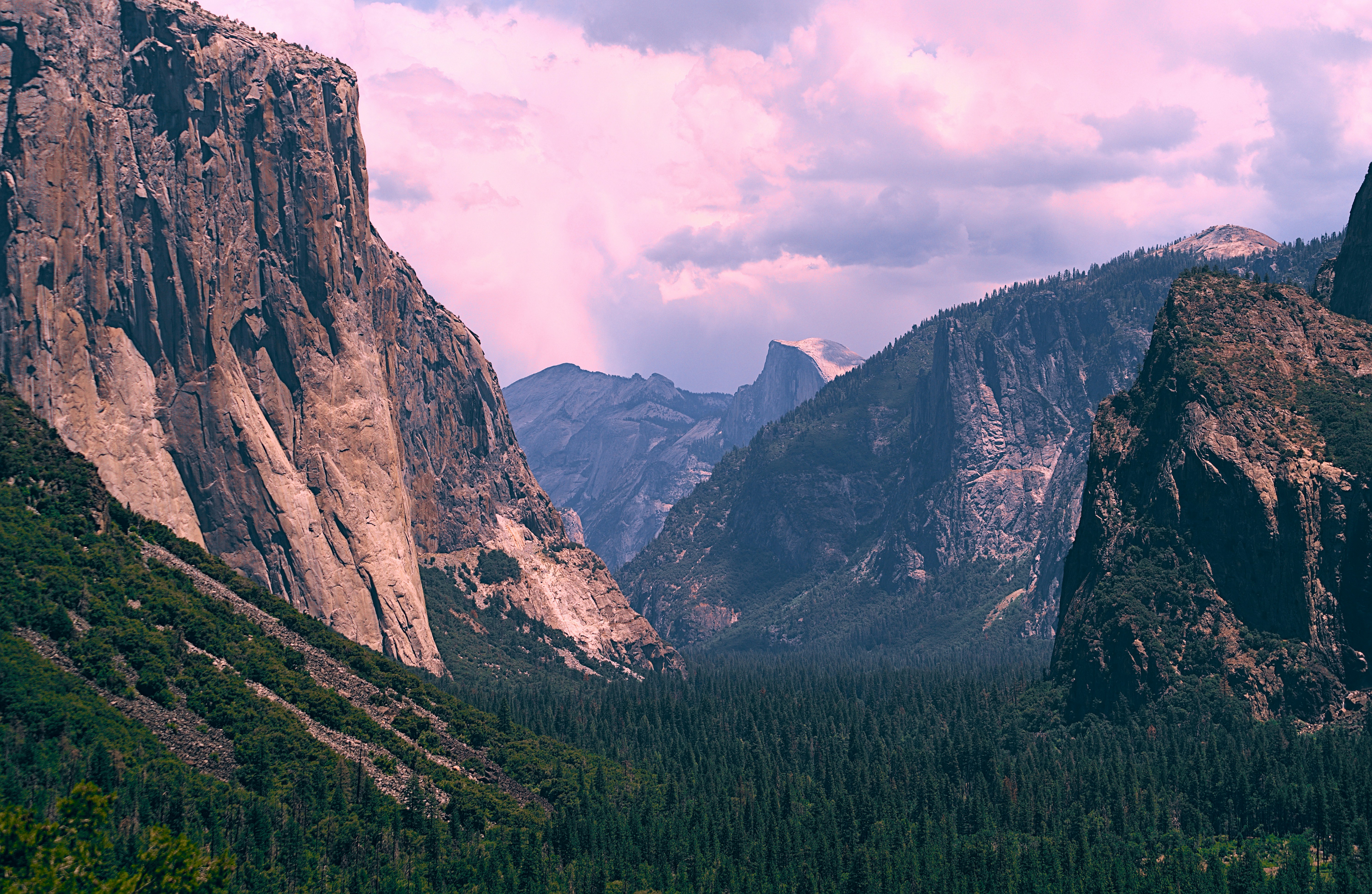 a view of a mountain range from a distance, Summer 22, Day 25 - Hiking at Yosemite National Park The park is truly a paradise. It has a large protected area covering approximately the same size as Rhode Island. We stopped by viewpoints of many iconic landmarks, including Half Dome, El Capitan, and Yosemite Falls. The park was home to breathtaking granite cliffs, cascading waterfalls, and a diverse selection of plant life. We covered popular destinations and hiked at a few of them.