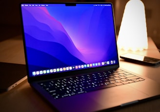 a laptop computer sitting on top of a wooden desk