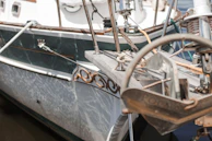 Close-up of a polished stainless steel yacht anchor resting on a pristine deck.
