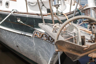 Close-up of a polished stainless steel yacht anchor resting on a pristine deck.