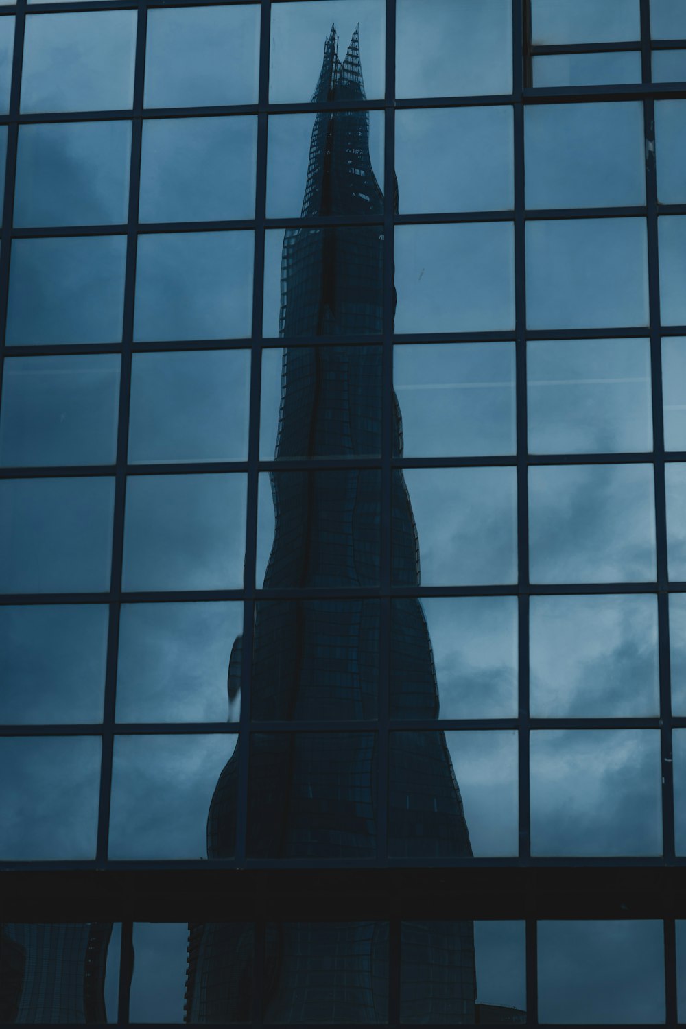 a tall building is reflected in the windows of another building
