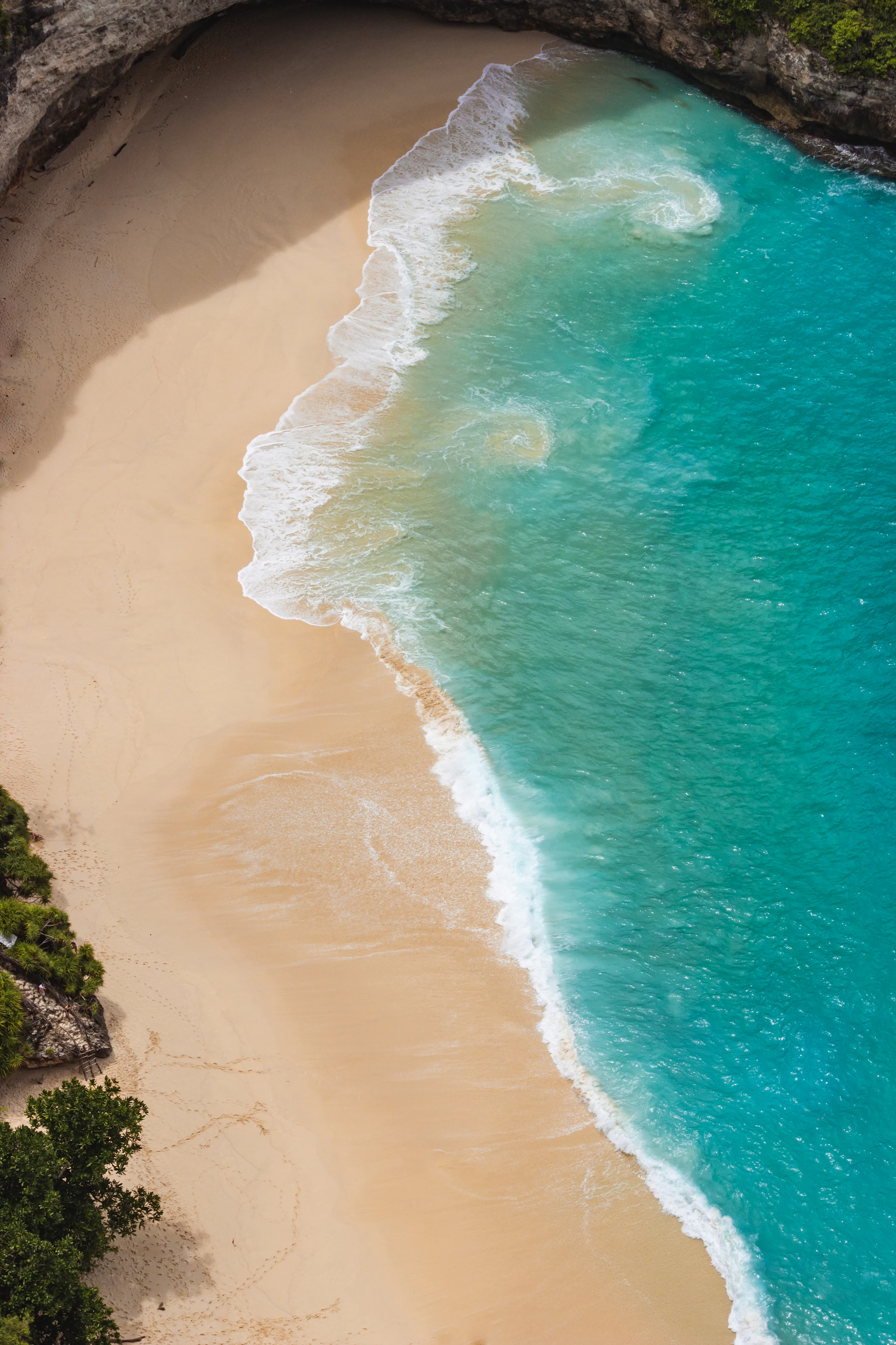 A breathtaking aerial view of a secluded luxury beach resort in Brazil at sunset, with golden sands and crystal-clear waters.