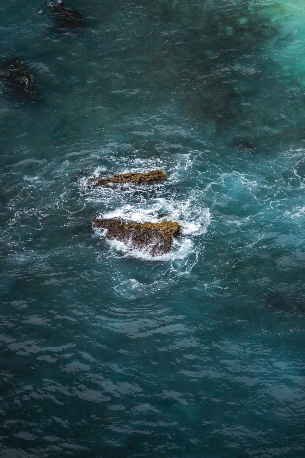 a couple of rocks sitting in the middle of a body of water