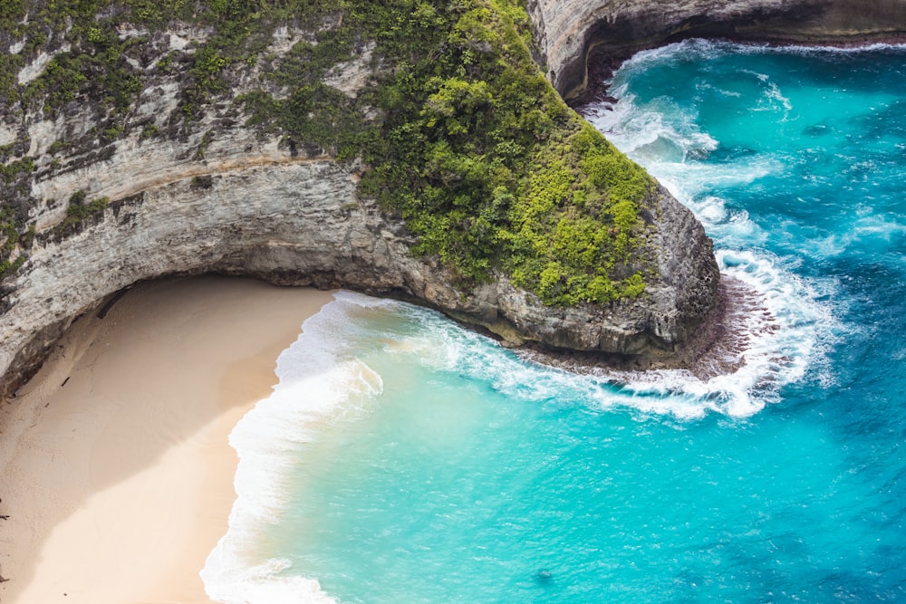 an aerial view of a sandy beach and a cliff