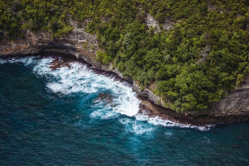 an aerial view of the ocean near a cliff