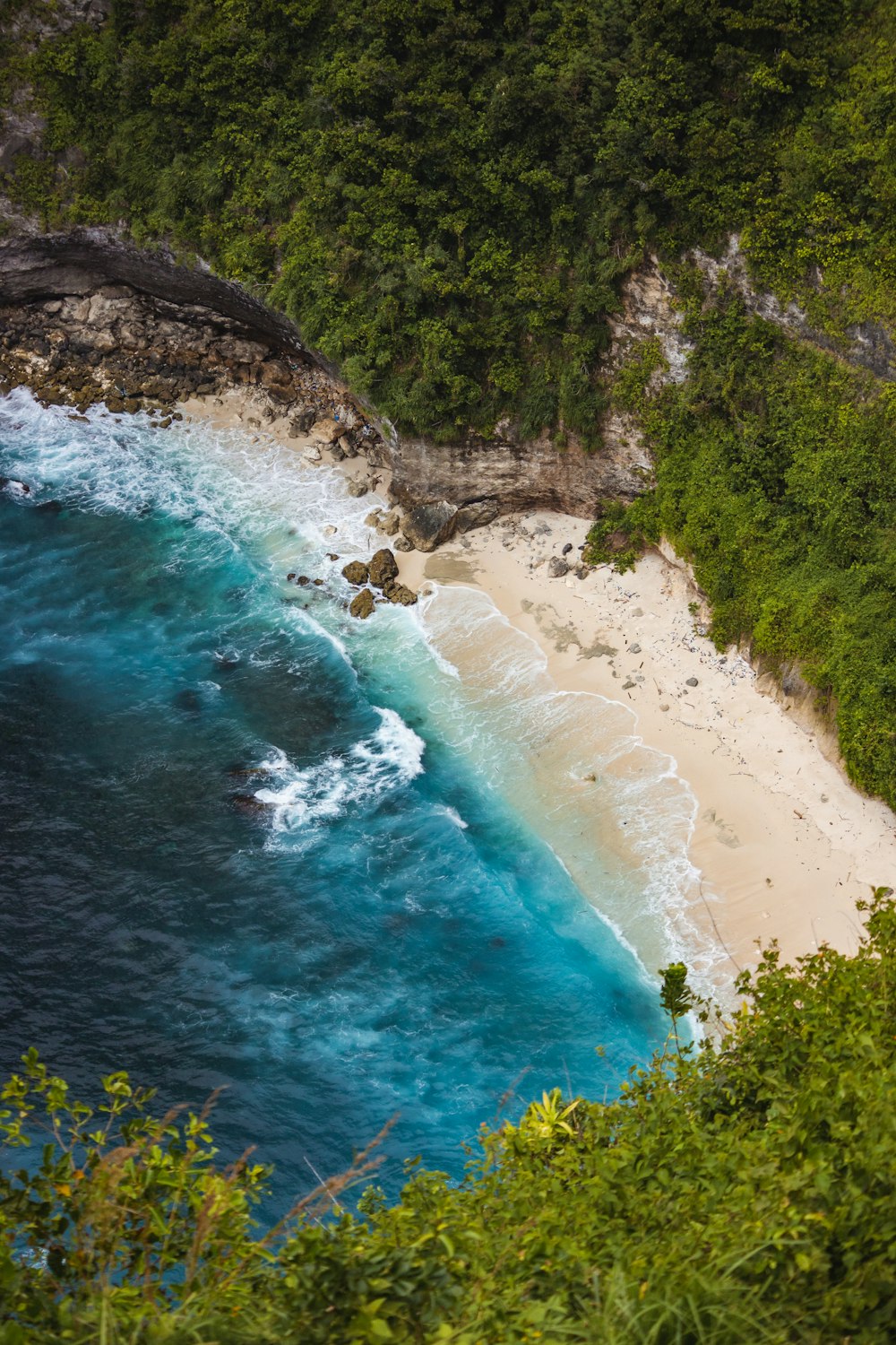 an aerial view of a sandy beach with blue water