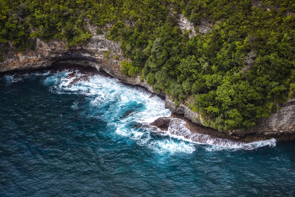 an aerial view of the ocean near a cliff