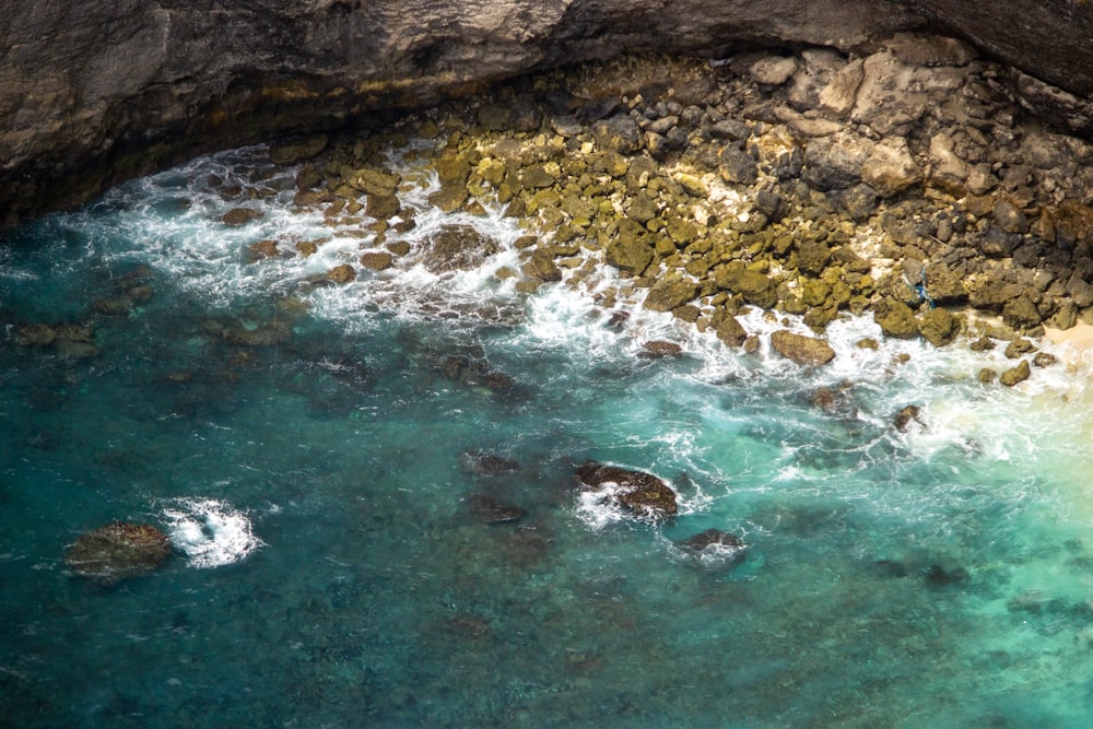 an aerial view of a body of water near a rocky shore