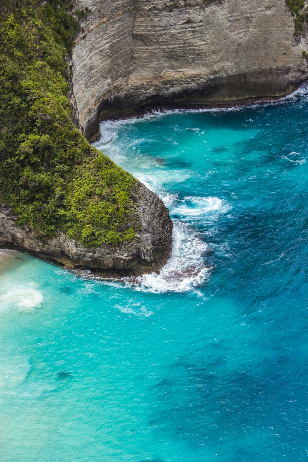 an aerial view of a beach with blue water