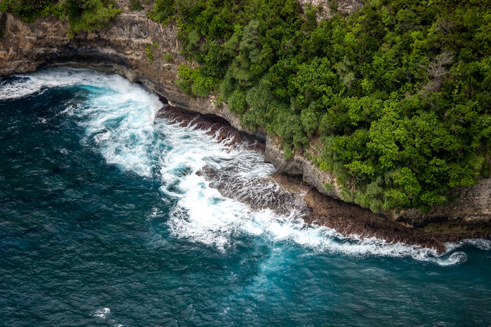 an aerial view of the ocean near a cliff