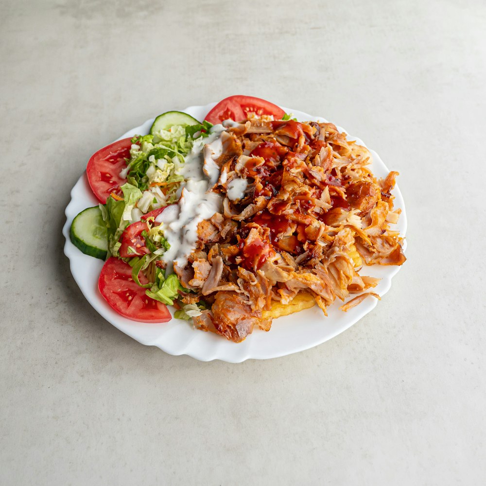 a white plate topped with a salad covered in toppings