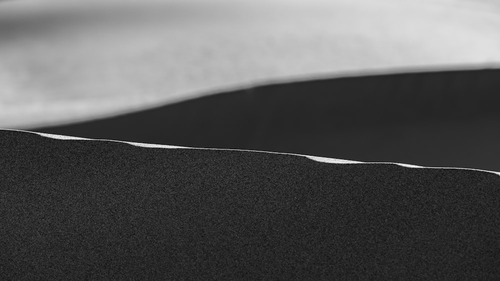 a black and white photo of a bed with white sheets