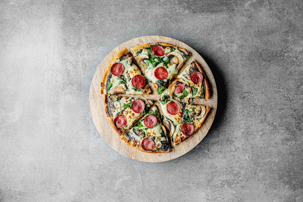 uma pizza sentada em cima de uma tábua de corte de madeira