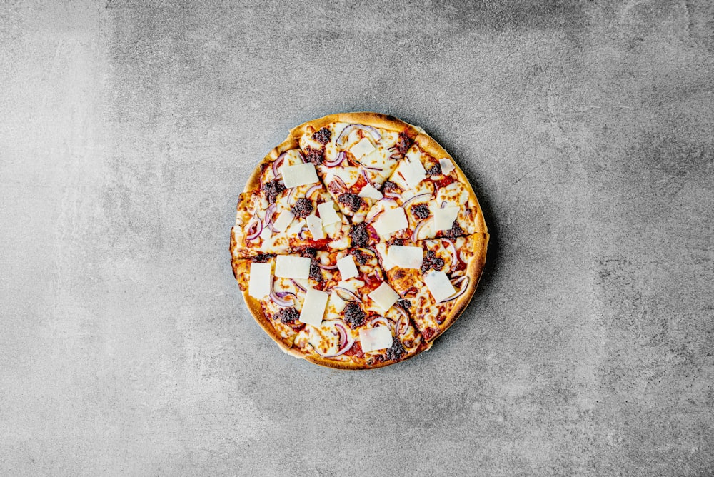 uma pizza sentada em cima de uma panela coberta de queijo