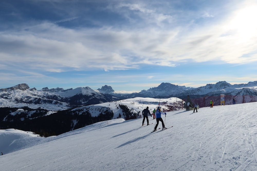 a group of people riding skis on top of a snow covered slope