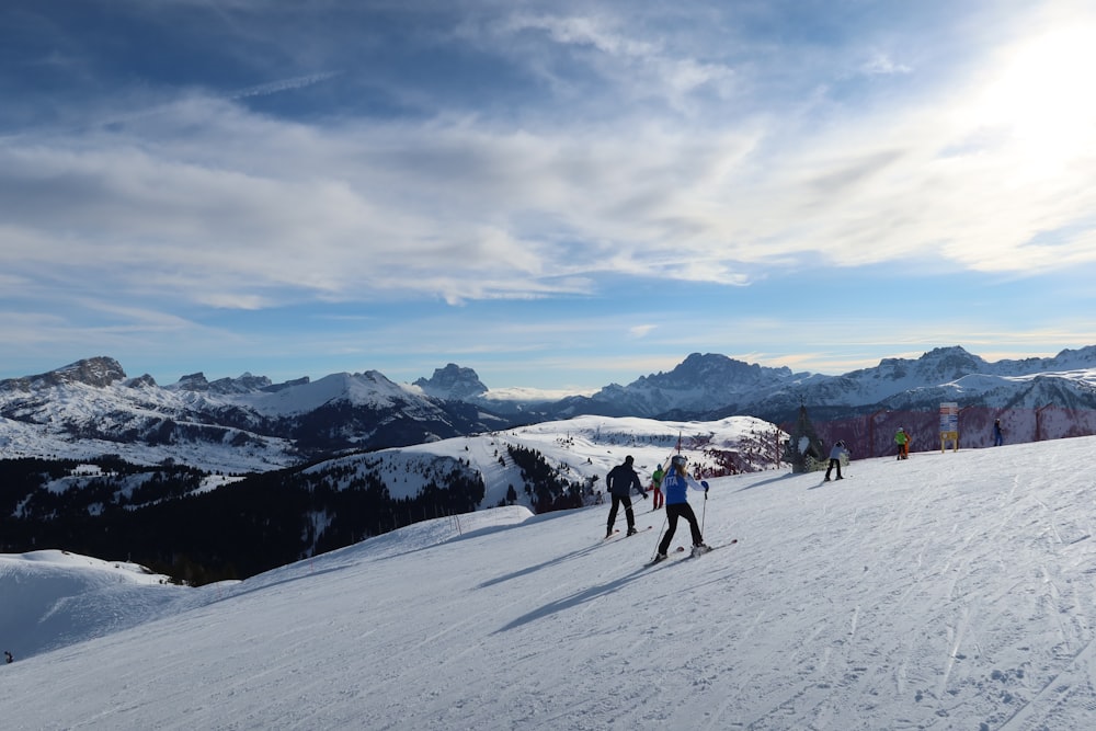 Eine Gruppe von Leuten, die auf Skiern auf einem schneebedeckten Hang fahren