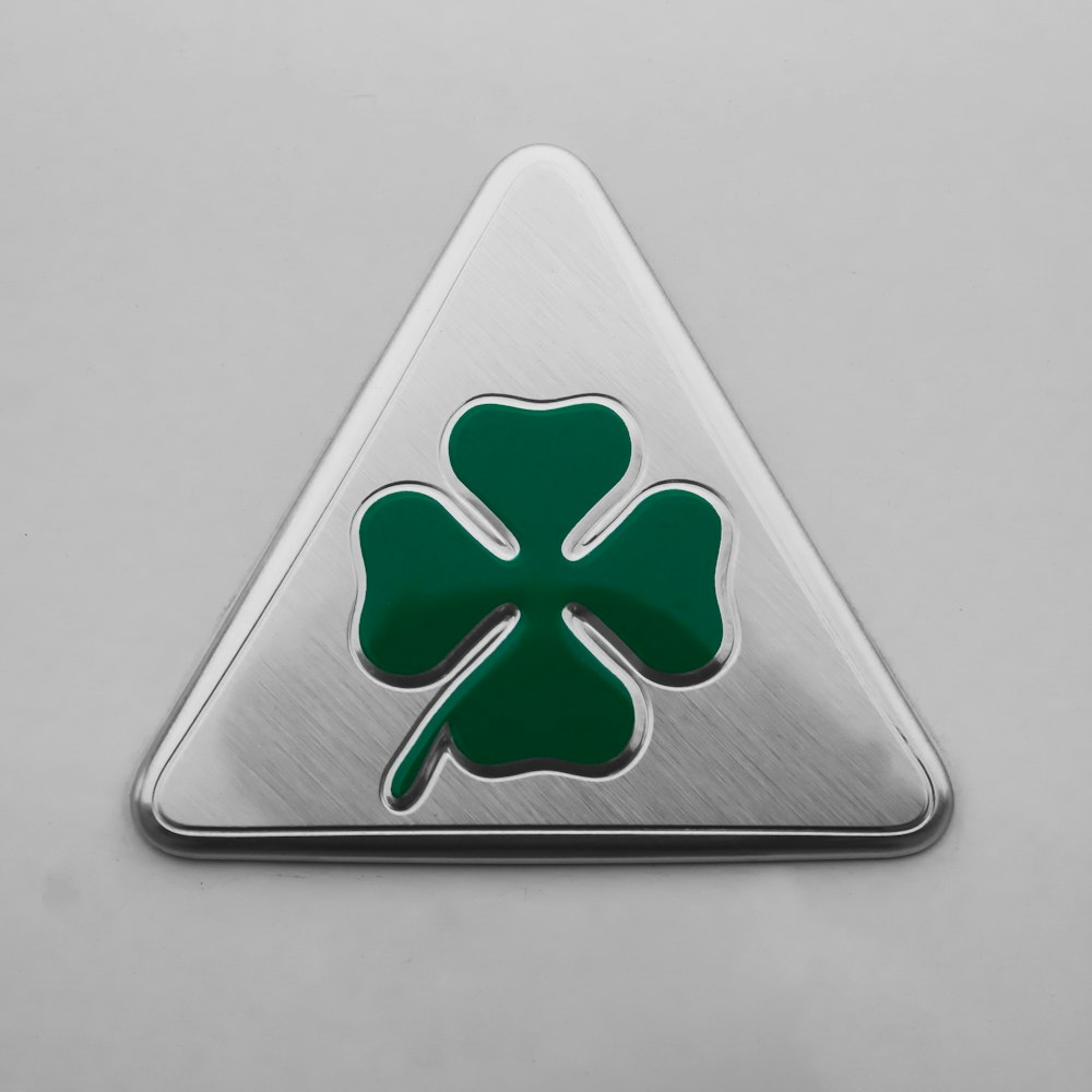 a metal triangle with a four leaf clover on it