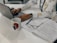 A person sitting at a desk, working on a laptop with a notepad and coffee.
