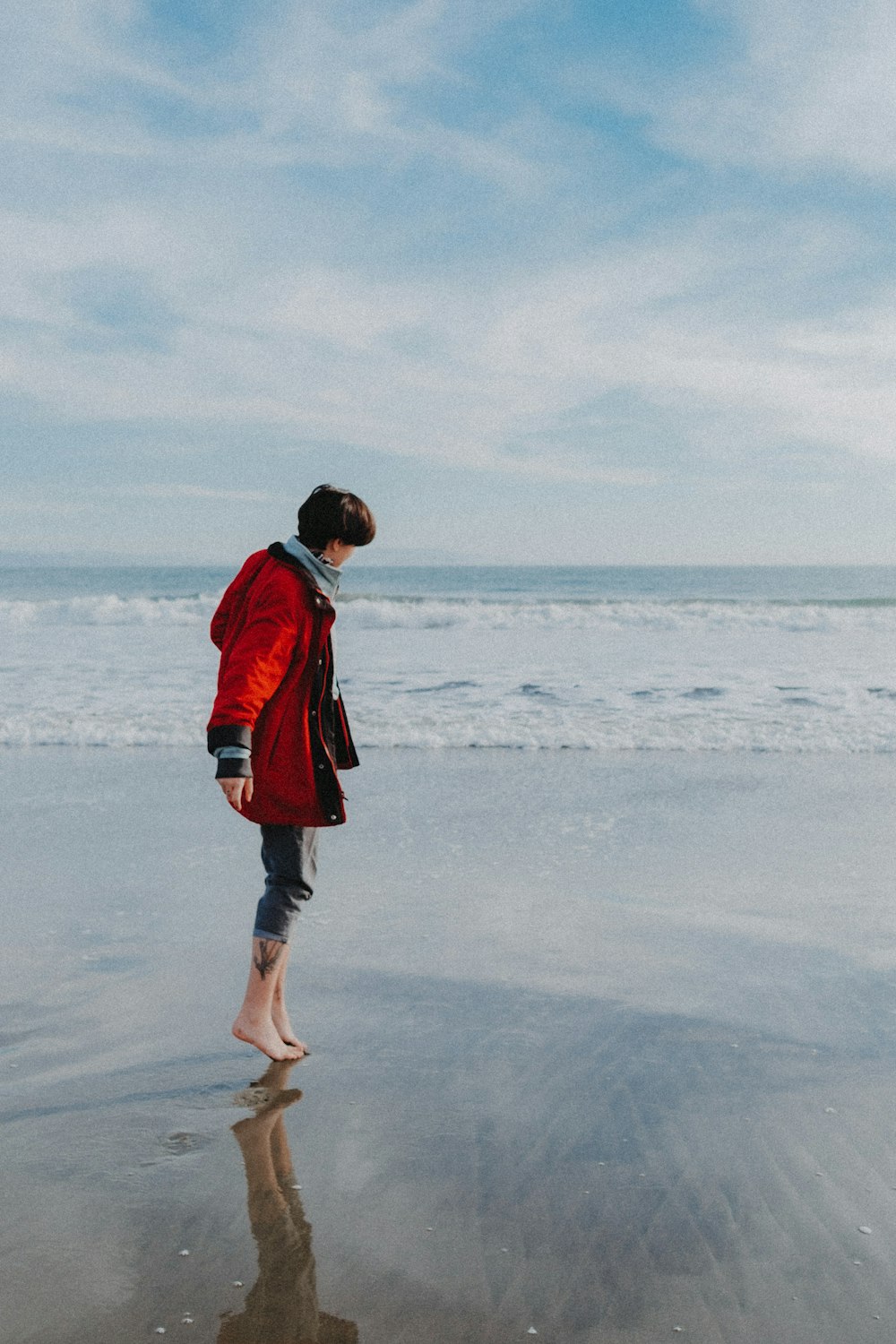 a man standing on a beach next to the ocean