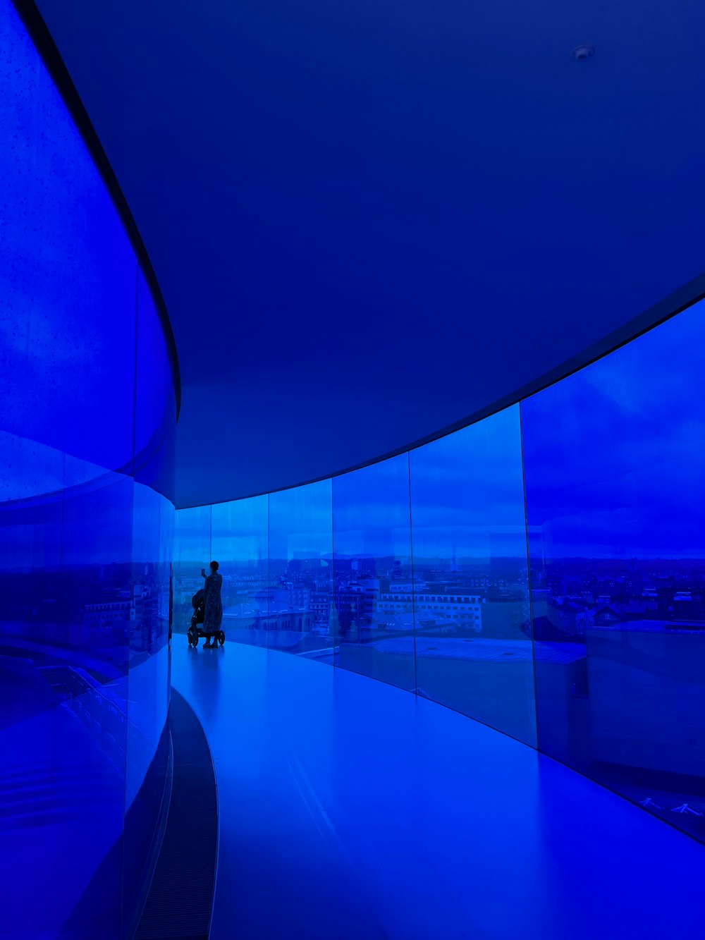 a person sitting on a bench in front of a blue wall