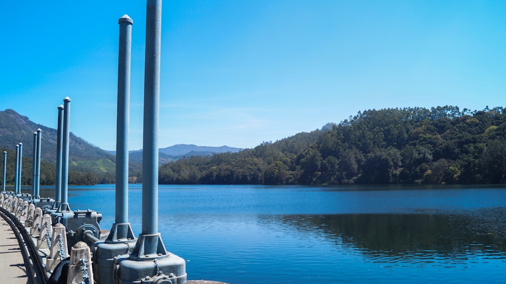 a row of metal poles next to a body of water