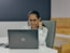 a woman sitting in front of a laptop computer